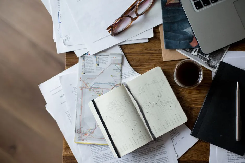 Documentos administrativos y mapas de cuenca hidrográfica sobre una mesa, representando los trámites legales para obtener permisos de captación de agua subterránea en España