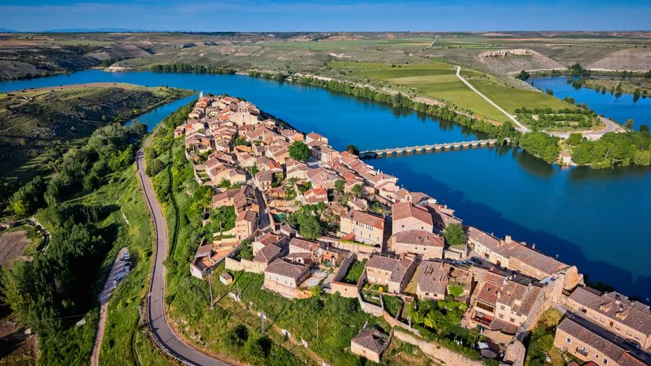 Vista aérea de un municipio rural español con red de abastecimiento de agua para municipios rurales y entorno agrícola